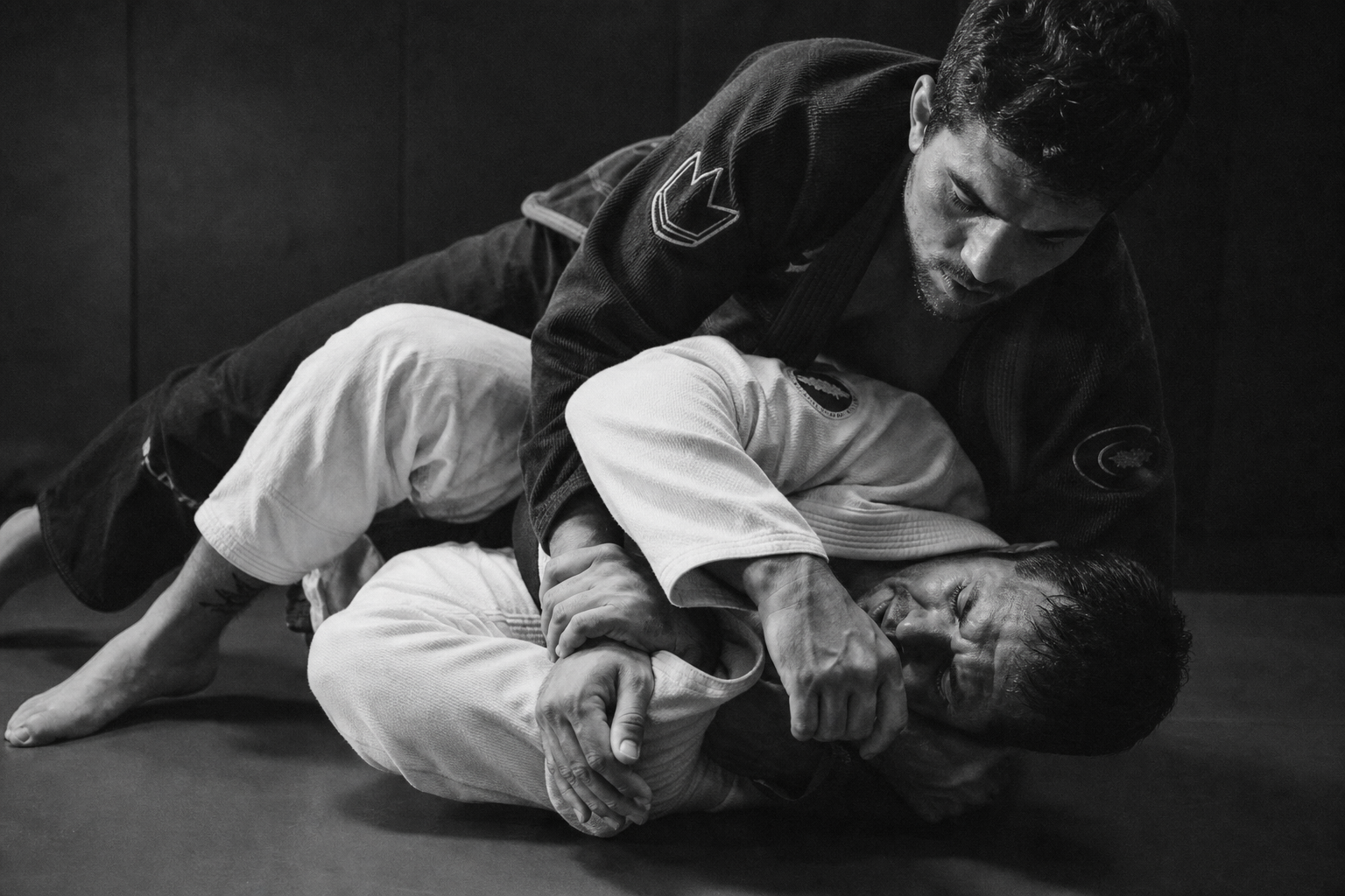 Deux pratiquants de jiu-jitsu brésilien au sol sur le tatami
